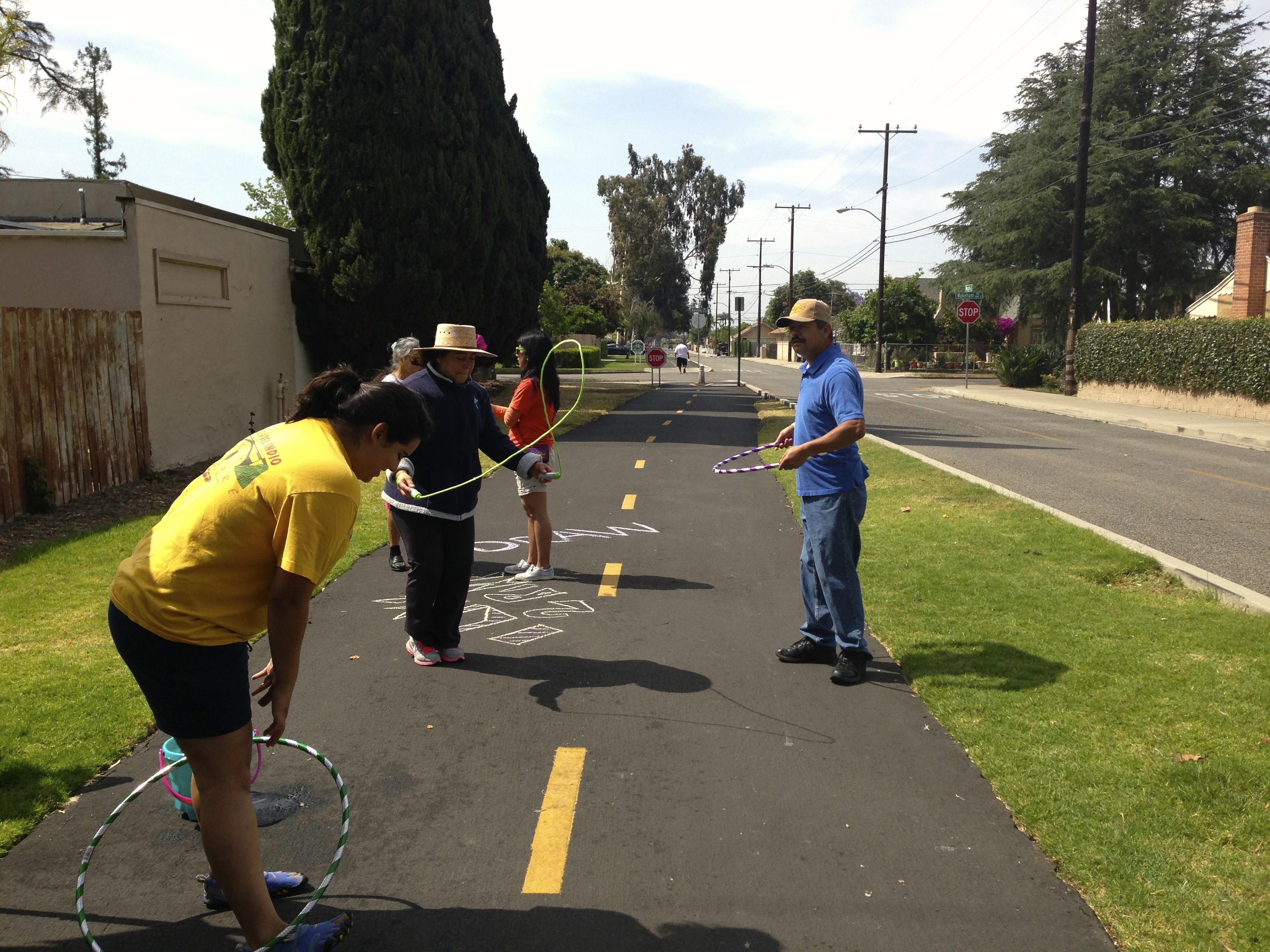 Santa Ana residents hula hoop and jump rope on the Pacific Electric Bike Trail. In 2012, Santa Ana residents that participated in the NeighborWorks Community Leadership Institute hosted a mini-open streets event at the Pacific Electric Bike Trail. Image: Santa Ana Active Streets